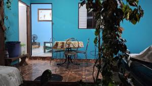 a room with a table and chairs and a blue wall at Casa entre a praia do Curral e cachoeira in Ilhabela