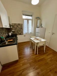 a kitchen with a white table and a white refrigerator at Appartamento Revoltella16 in Trieste