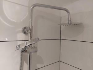 eine Dusche mit einem verchromten Duschkopf im Bad in der Unterkunft Thornton Road Lodge -Room 2 in Bradford