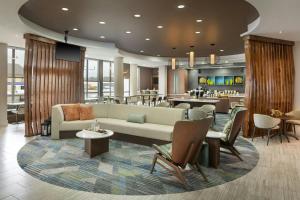 a lobby with a couch and chairs and a bar at SpringHill Suites by Marriott Wichita Airport in Wichita