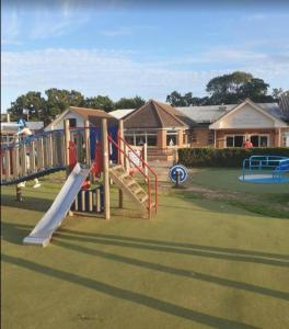 a playground with a slide in a yard at Coastal Retreats in Great Clacton