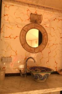 a bathroom with a sink and a mirror on a wall at Desert Agafay Luxury Camp in El Karia