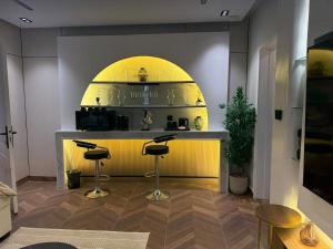 a bar with stools in a room with a yellow counter at الملقا جاكوزي لوفت Al Malqa Jacuzzi Loft in Riyadh