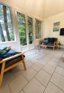 a living room with large windows and a tiled floor at Le Vue sur Seine in Bardouville