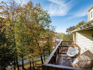 a porch with two rocking chairs and trees at Beech Mountain Escape with Views in Beech Mountain