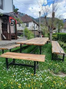 three wooden picnic tables sitting in the grass at Mujagin Han in Srebrenica