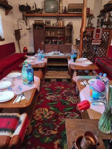 a living room with tables and chairs and a tv at Mujagin Han in Srebrenica