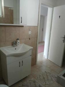 a bathroom with a sink and a mirror and a door at Mujagin Han in Srebrenica +3 photos