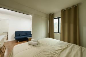a bedroom with a large bed and a blue couch at Hotel Av Ibirapuera 2534 Moema São Paulo 1102 in Sao Paulo +22 photos