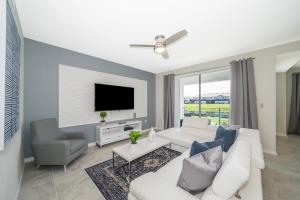 Una sala de estar con un sofá blanco y un televisor. en 3111-102RD CONDO 2 BEDS/2 BATHS (SANITIZED), en Kissimmee