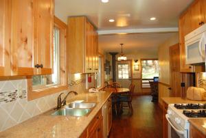 a kitchen with wooden cabinets and a sink and a table at Ox Yoke in North Wawona