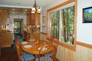a dining room with a table and chairs and a kitchen at Ox Yoke in North Wawona