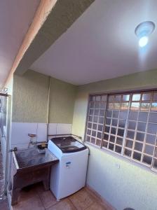 a room with a small refrigerator and a window at Casa Aconchegante in Foz do Iguaçu