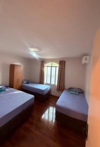 a room with two beds and a window at Casa Aconchegante in Foz do Iguaçu