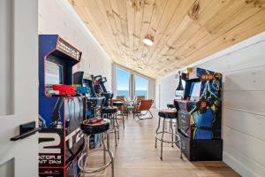 a room with a bunch of arcade games and stools at Sundune in Gulf Shores