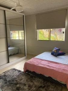 a bedroom with a bed and a large mirror at Residencial Moradas das cachoeiras 10 minutos da Praia Guarda Do Embaú SC in Palhoça