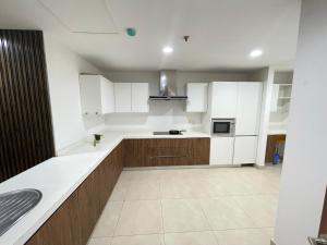 拉合尔Modern Luxury 1 BHK Apartment At Goldcrest Mall DHA Phase 4 Lahore的厨房配有木制橱柜和白色家电