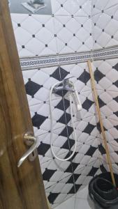 a bathroom with a hose on a black and white tiled floor at Appart hôtel tanger in Tangier +5 photos