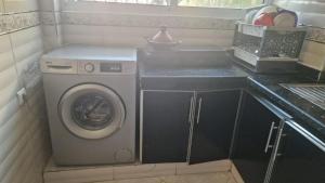 a small kitchen with a washing machine in a kitchen at Appart hôtel tanger in Tangier