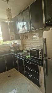 a kitchen with a microwave and a stove top oven at Appart hôtel tanger in Tangier