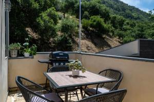 a table and chairs on a balcony with a grill at The Malibu Retreat Apartments in Malibu Beach