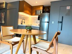 a kitchen with a wooden table and a refrigerator at STAY Sun Square in Goiânia