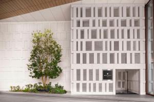 东京JW Marriott Hotel Tokyo的一栋白色建筑，前面有一棵树