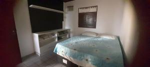 ein Schlafzimmer mit einem Bett und einem Flachbildfernseher in der Unterkunft Casa de Praia em Paripueira in Paripueira