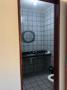 ein Badezimmer mit einem Spiegel, einem Waschbecken und einem WC in der Unterkunft Casa de Praia em Paripueira in Paripueira + 11 Fotos