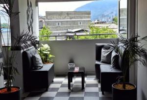 a balcony with two chairs and a table with plants at Hotel Playa Itagui in Itagüí