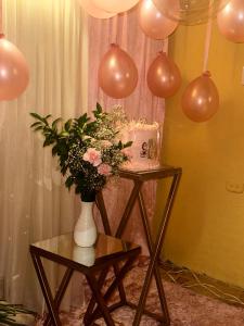 a table with a cake and a vase with flowers at APARTAMENTO CÉNTRICO con PISCINA a UNA CUADRA in Santa Fe de Antioquia +16 photos