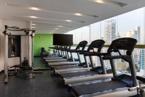 a gym with rows of tread machines and a flat screen tv at Hampton by Hilton Cartagena in Cartagena de Indias