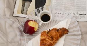 a cup of coffee and a croissant and an apple at Atmosfere 19 in Sant'Egidio del Monte Albino