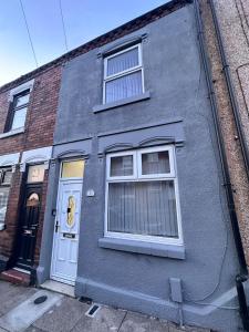 un edificio gris con dos ventanas y una puerta en de gold ltd, en Stoke on Trent 20 fotos más