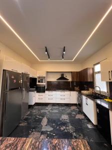 Sheikh ZayedThe white kingdom的一间大厨房,配有白色橱柜和不锈钢用具