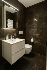 a bathroom with a white sink and a toilet at Lux Line Apartment in Zürich +2 photos