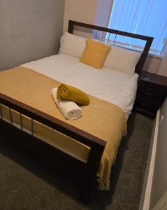 a bed with a wooden frame and a yellow towel on it at Heart of Aberdeen in Aberdeen