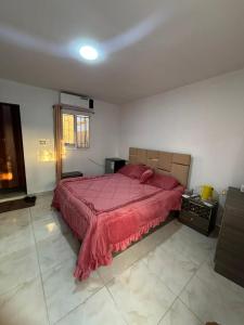 a bedroom with a large bed with a red bedspread at petra towering rock in Wadi Musa