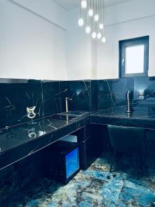 a black bathroom with two sinks and a chair at Pensiunea Gloria in Afumaţi