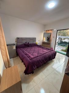 a bedroom with a bed with a purple comforter at petra towering rock in Wadi Musa