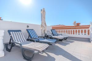 three blue chairs sitting on a balcony with a view at Villa Vinidum ,CINEMA&PRIVATE POOL&JACUZZI in Arona
