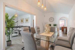 a living room with a glass table and chairs at Villa Vinidum ,CINEMA&PRIVATE POOL&JACUZZI in Arona
