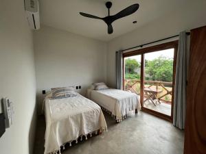 sypialnia z dwoma łóżkami i dużym oknem w obiekcie Casa Jubilee 6 two twins or king w mieście Puerto Escondido