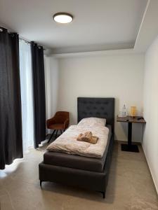 a bedroom with a bed and a table and a chair at Hotel Akropolis in Herford