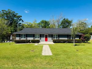 a house with a red door on a green yard at Home Away from Home in Fitzgerald
