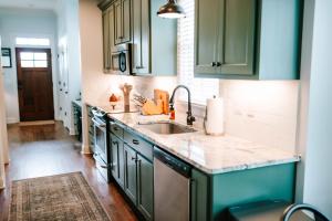 a kitchen with green cabinets and a sink at Stylish 2br Cabin C By Mhm Luxury Properties in Jasper +28 photos