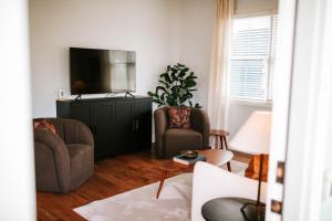 a living room with two chairs and a flat screen tv at Stylish 2br Cabin C By Mhm Luxury Properties in Jasper