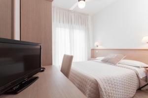 A television and/or entertainment centre at B&B Airone Cervia - Camere e Appartamenti