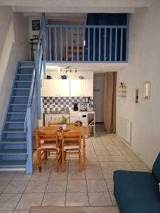 a dining room with a table and chairs and a staircase at Appartement T2 entre mer et lac in Port-la-Nouvelle