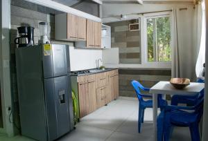a kitchen with a refrigerator and a table with chairs at Casa de Vacaciones ECOWASI VERAS in Capurganá
